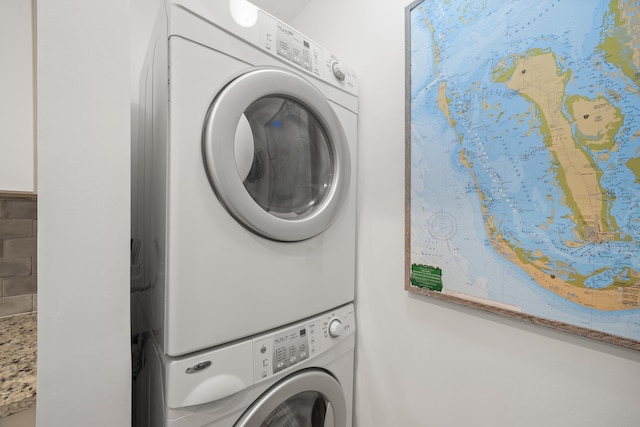 clothes washing area with stacked washer and clothes dryer