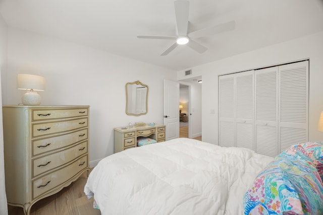 bedroom featuring ceiling fan, light hardwood / wood-style flooring, and a closet