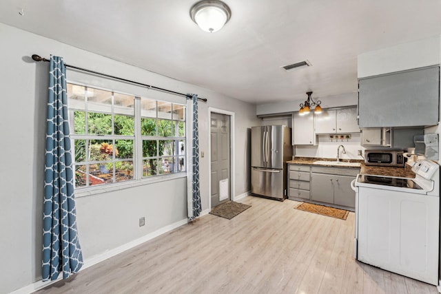 kitchen featuring sink, gray cabinets, light wood-type flooring, appliances with stainless steel finishes, and a chandelier