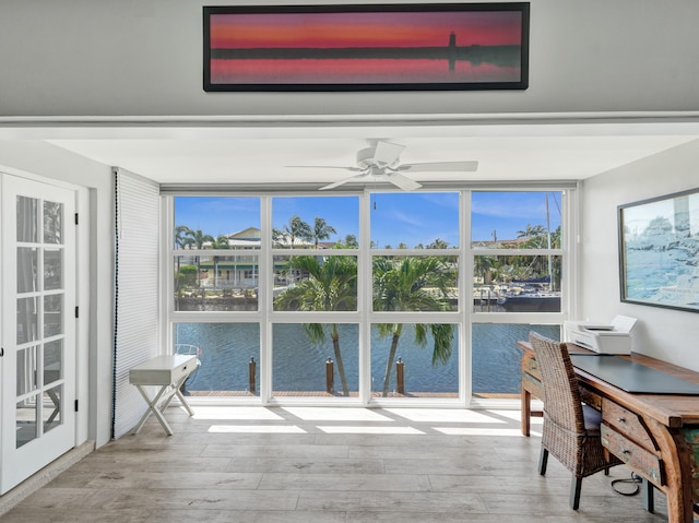 sunroom / solarium with a water view and ceiling fan