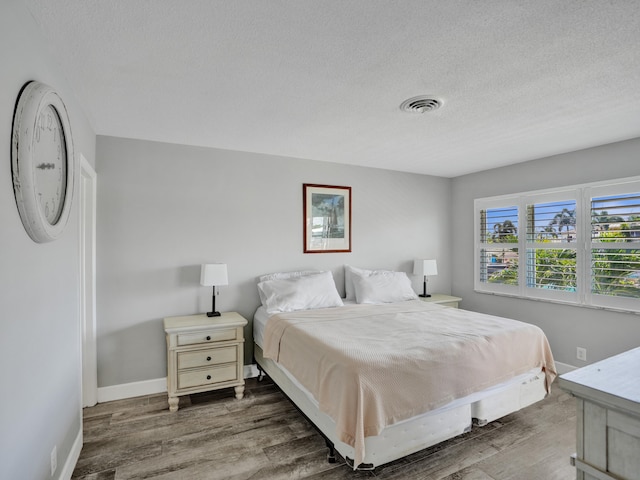 bedroom featuring hardwood / wood-style floors and a textured ceiling