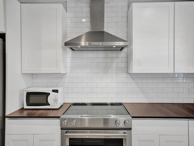 kitchen featuring white cabinets, tasteful backsplash, wall chimney exhaust hood, and stainless steel stove