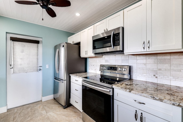 kitchen with tasteful backsplash, white cabinetry, stainless steel appliances, light stone counters, and light tile patterned floors