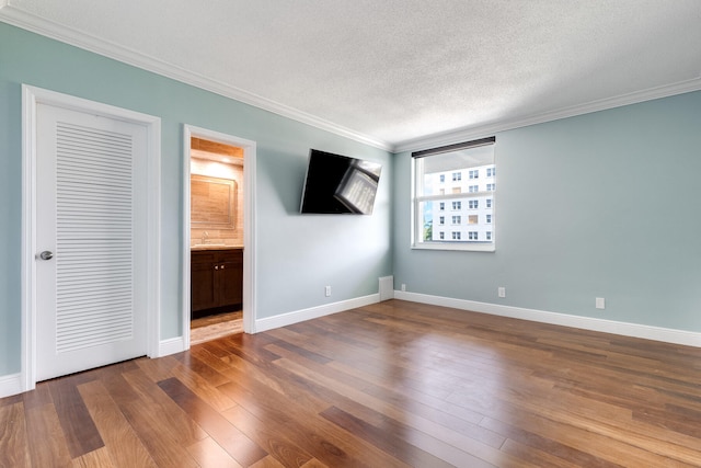 interior space featuring sink, hardwood / wood-style floors, crown molding, and a textured ceiling