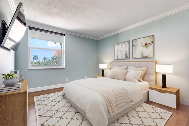 bedroom with crown molding, a textured ceiling, and wood-type flooring