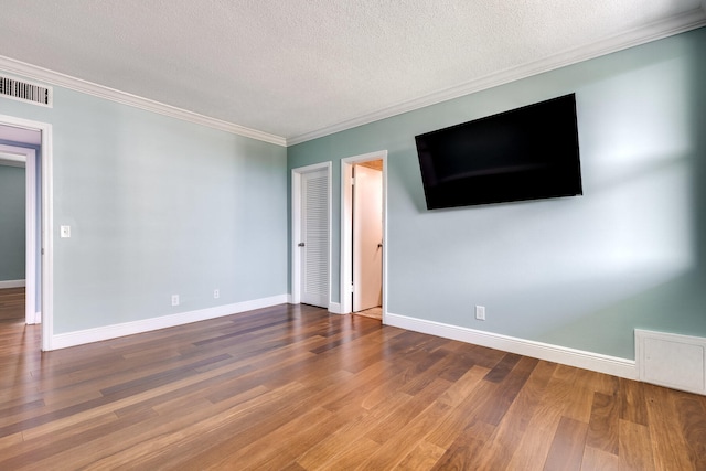 unfurnished room with hardwood / wood-style flooring, a textured ceiling, and ornamental molding