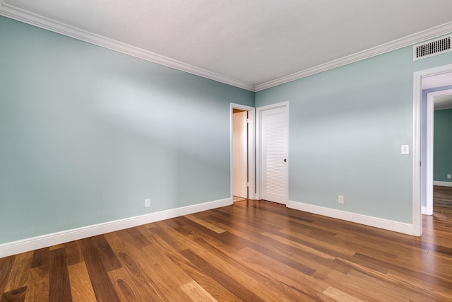 spare room featuring crown molding and hardwood / wood-style floors