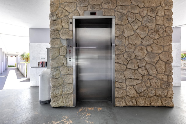 room details featuring elevator and concrete flooring