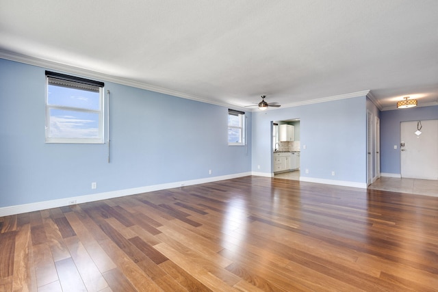 spare room with crown molding, hardwood / wood-style flooring, sink, and ceiling fan