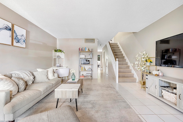 living room with a textured ceiling and light tile patterned floors