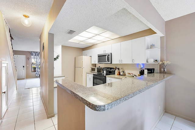 kitchen with kitchen peninsula, white cabinets, appliances with stainless steel finishes, a textured ceiling, and tasteful backsplash