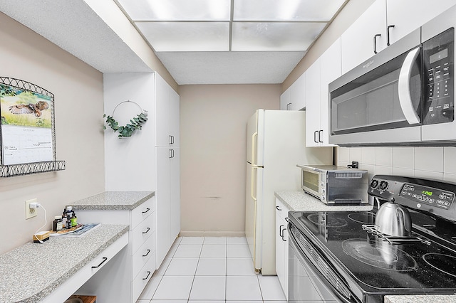 kitchen with white cabinetry, stainless steel appliances, and light tile patterned flooring