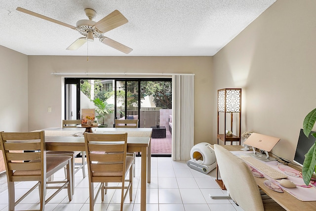 tiled dining space with a textured ceiling and ceiling fan