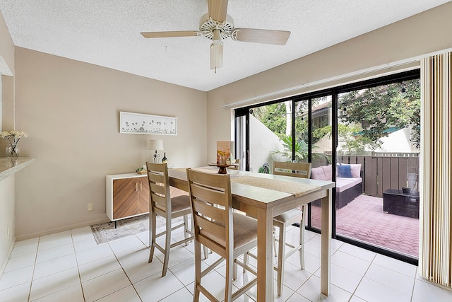 dining room with ceiling fan, a textured ceiling, and light tile patterned flooring