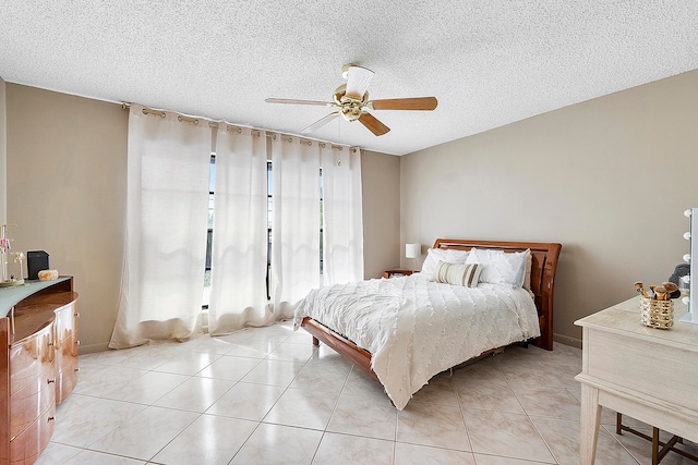 bedroom featuring ceiling fan, a textured ceiling, and light tile patterned flooring