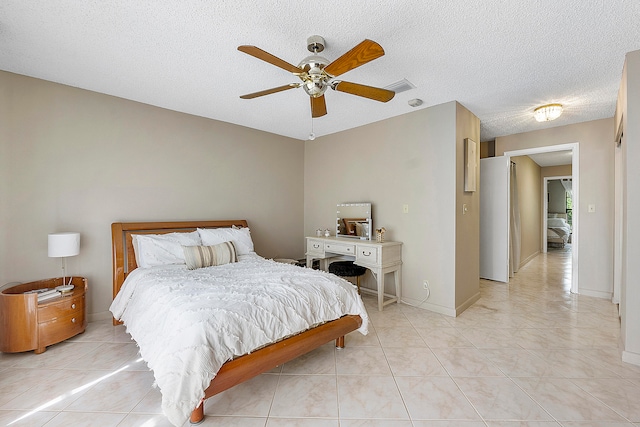 bedroom featuring a textured ceiling, light tile patterned floors, and ceiling fan