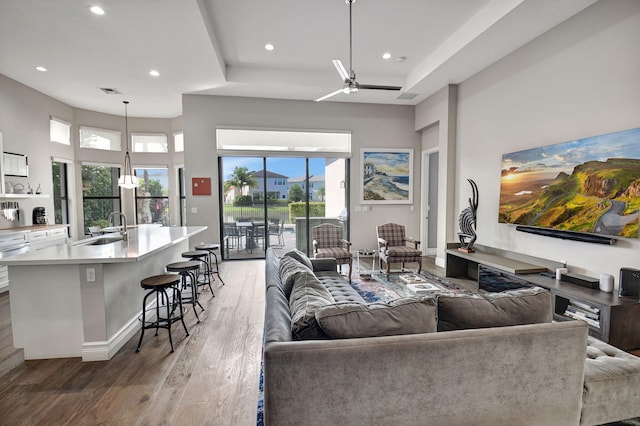 living room with dark hardwood / wood-style floors, a healthy amount of sunlight, sink, and ceiling fan