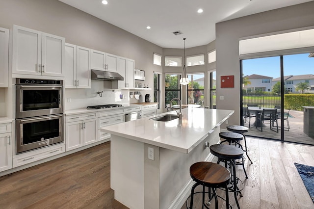 kitchen with appliances with stainless steel finishes, white cabinetry, and a wealth of natural light