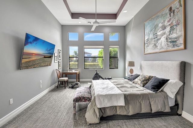 bedroom with carpet flooring, a tray ceiling, and ceiling fan