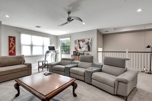 carpeted living room with a textured ceiling and ceiling fan