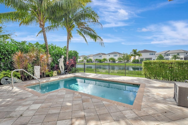 view of swimming pool featuring a patio area and a water view