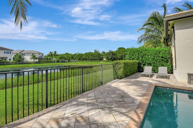 view of patio / terrace with a fenced in pool and a water view