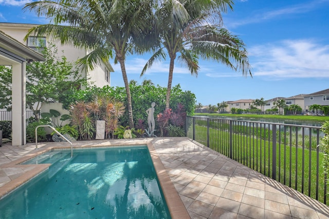 view of pool featuring a patio area, a yard, and a water view