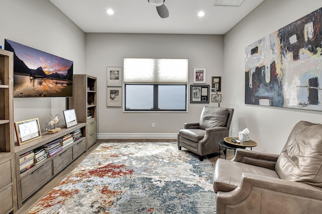 living area with hardwood / wood-style flooring and ceiling fan