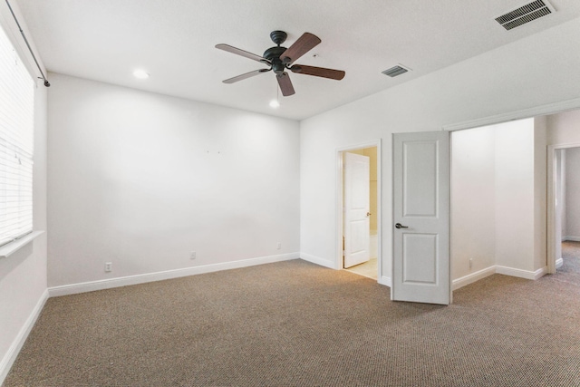 spare room with ceiling fan and light carpet