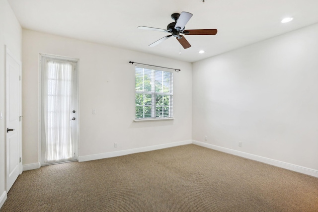 carpeted spare room featuring ceiling fan