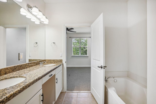 bathroom with a bath, ceiling fan, vanity, and tile patterned flooring