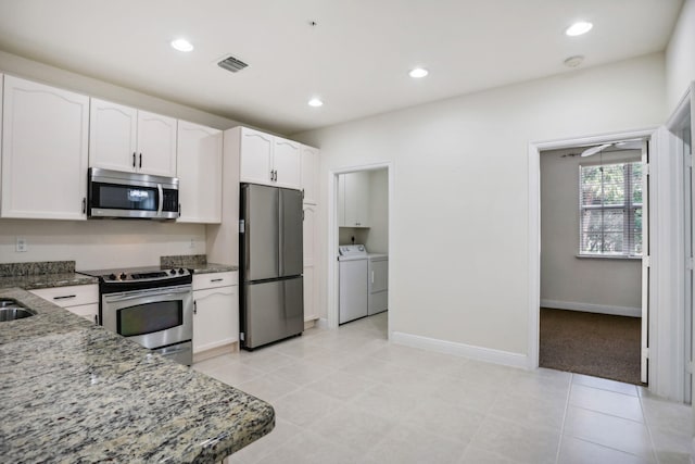 kitchen featuring white cabinetry, appliances with stainless steel finishes, stone counters, and separate washer and dryer