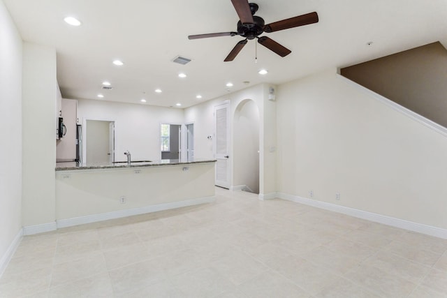 unfurnished living room with ceiling fan and light tile patterned floors