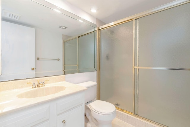 bathroom featuring vanity, toilet, and an enclosed shower