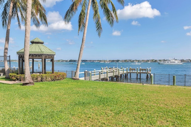 dock area featuring a gazebo, a water view, and a lawn