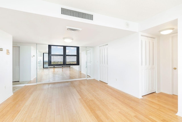 spare room with expansive windows and hardwood / wood-style flooring