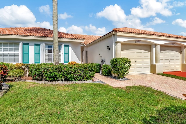 mediterranean / spanish home with a front lawn and a garage