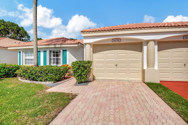 mediterranean / spanish-style home featuring a front yard and a garage