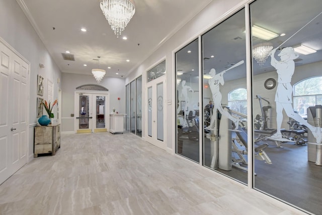 hall with french doors, ornamental molding, and a notable chandelier