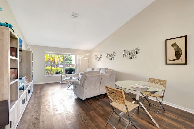 living room with dark wood-type flooring and vaulted ceiling