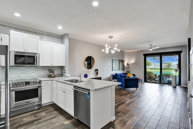 kitchen featuring stainless steel appliances, white cabinets, sink, and kitchen peninsula