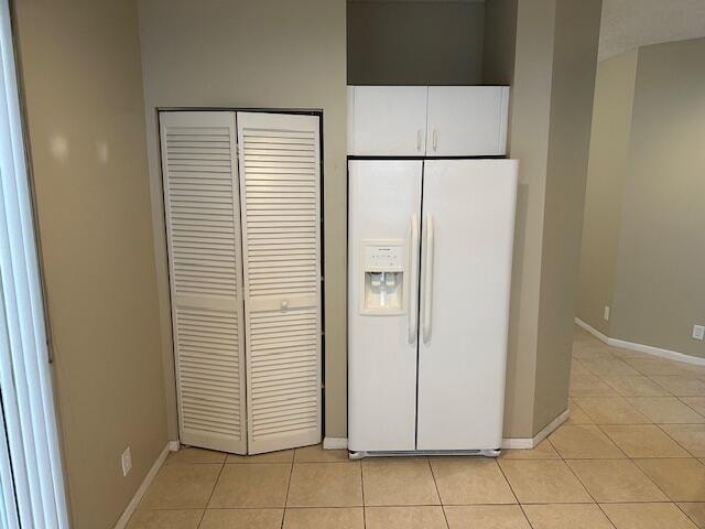 interior details featuring light tile patterned floors and white refrigerator with ice dispenser