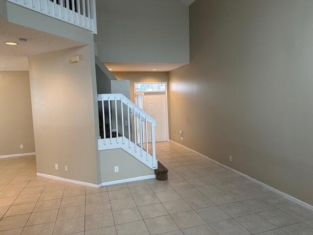 staircase featuring a high ceiling and tile patterned flooring