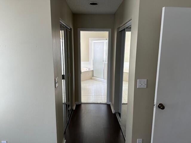 hallway with dark tile patterned flooring