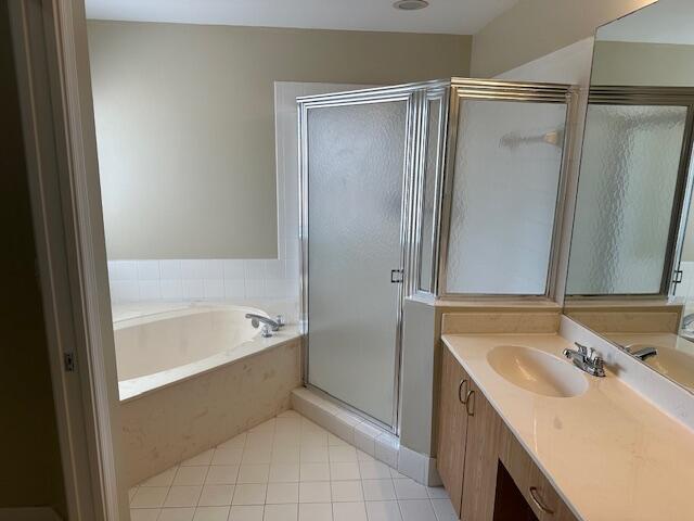 bathroom with vanity, tile patterned floors, and plus walk in shower