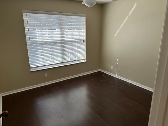 spare room featuring dark hardwood / wood-style floors and ceiling fan