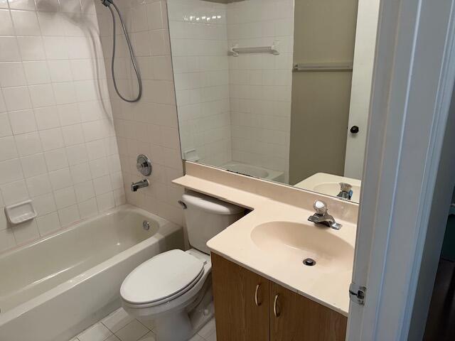 full bathroom featuring tiled shower / bath, vanity, toilet, and tile patterned flooring