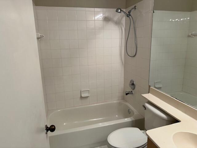 full bathroom with toilet, tiled shower / bath, and vanity