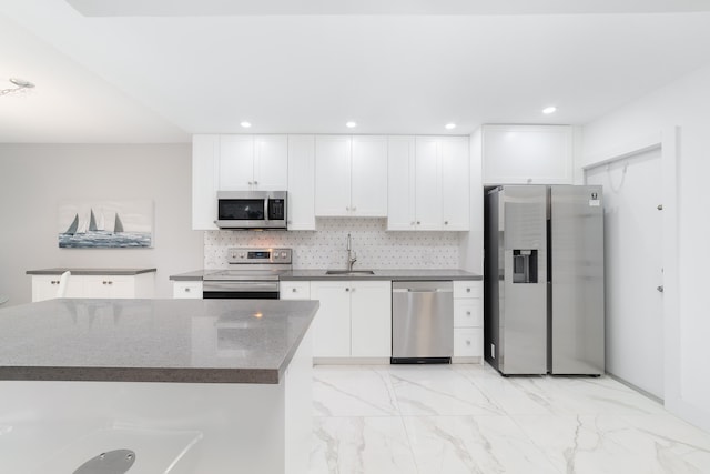 kitchen with white cabinetry, tasteful backsplash, stainless steel appliances, and sink