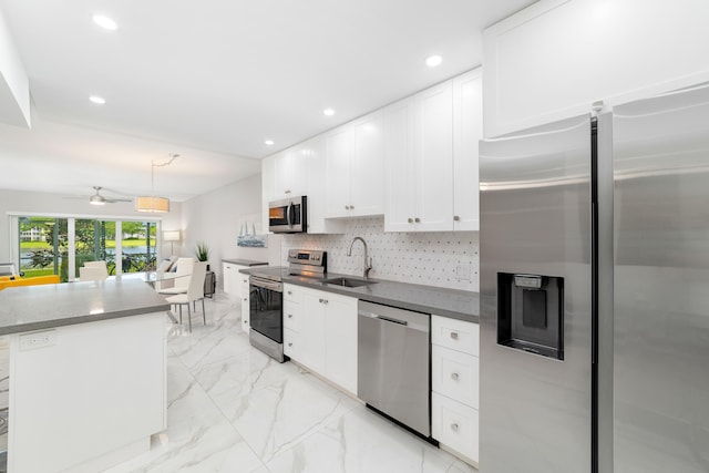 kitchen with backsplash, sink, white cabinets, appliances with stainless steel finishes, and ceiling fan